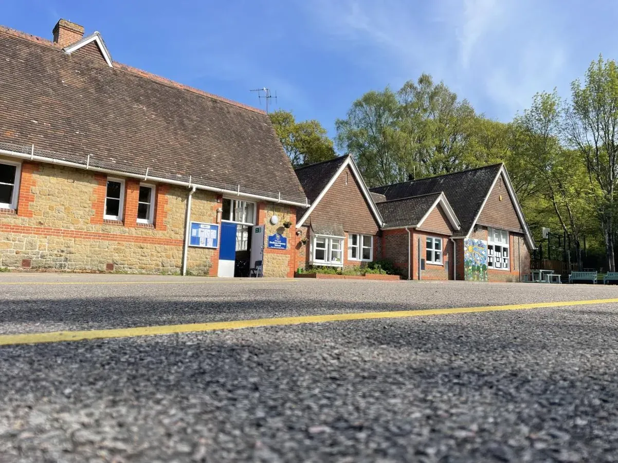 The Victorian brick school building at Stedham with its playground in front