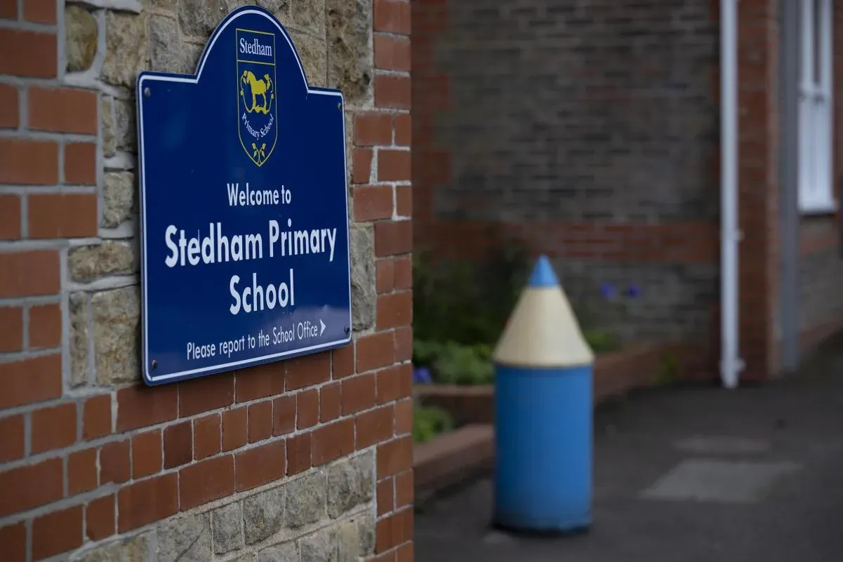 The blue Welcome to Stedham Primary School sign by the entrance